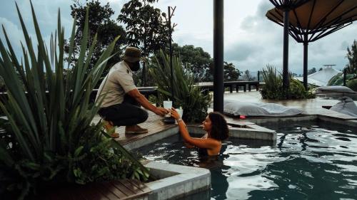 a man and a woman in a swimming pool at Bosko in Guatapé