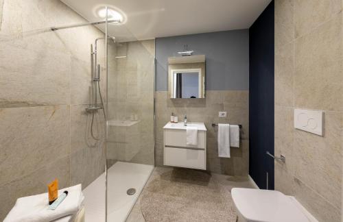y baño con ducha, aseo y lavamanos. en Residence Casa Coppa Appartamento Iris, en Omegna