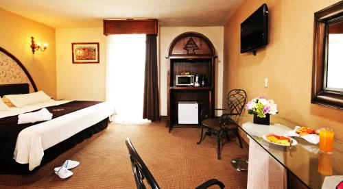 a hotel room with a bed and a dining room at Hotel & Spa Hacienda Baruk in Zacatecas