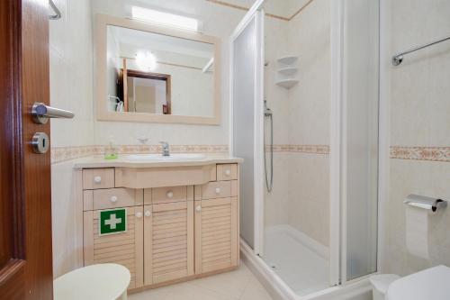 y baño con lavabo, ducha y aseo. en Alvor Vila Marachique Apartment en Alvor
