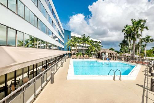 an exterior view of a building with a swimming pool at Sonesta Miami Airport in Miami