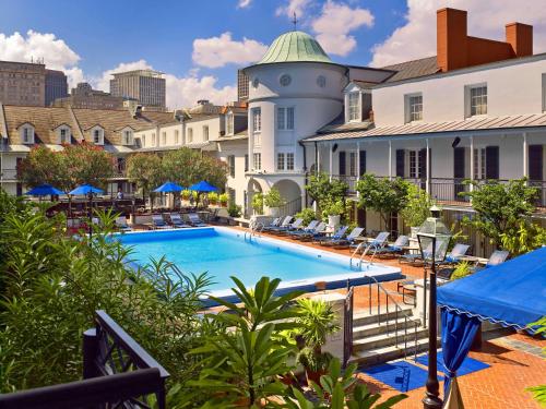 vista sulla piscina di un hotel con sedie e un edificio di The Royal Sonesta New Orleans a New Orleans