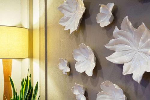 a wall with white flowers on a wall at Sonesta Atlanta Airport North in Atlanta