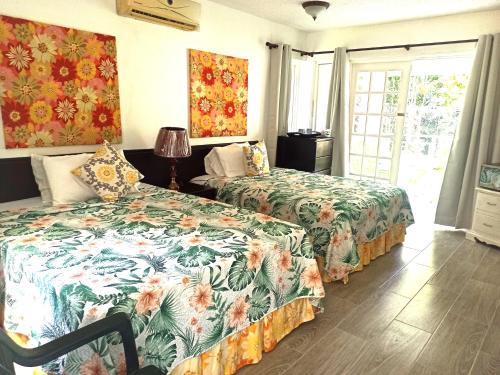 a bedroom with two beds and a window at Mystic Ridge Apt 26F in Ocho Rios