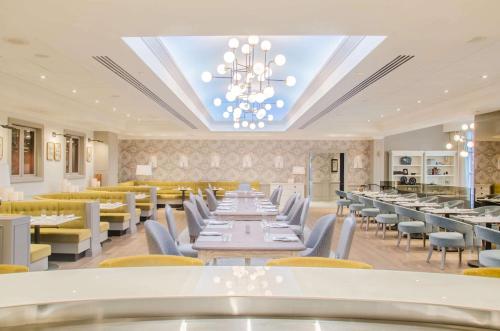 a restaurant with tables and chairs and a chandelier at The Yorkville Royal Sonesta Hotel Toronto in Toronto