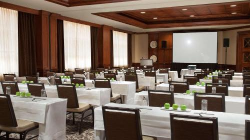 a conference room with tables and chairs and a screen at The Yorkville Royal Sonesta Hotel Toronto in Toronto