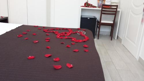 a bunch of red rose petals on a bed at Orchidea Rooms & Suites in Civitanova Marche