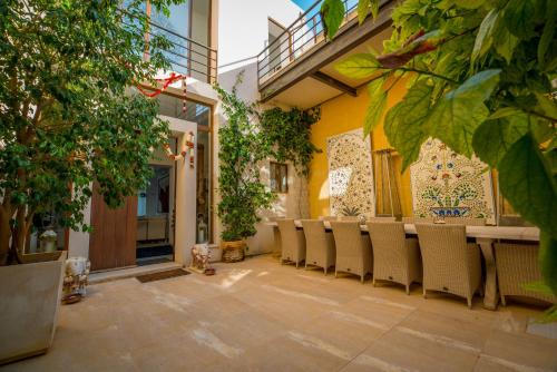 a patio with a long table and chairs at ALTO Beyond in Xagħra