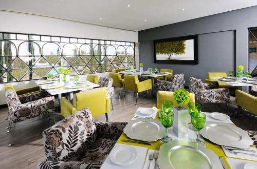 a dining room with tables and yellow chairs at Hotel & Spa Hacienda Baruk in Zacatecas