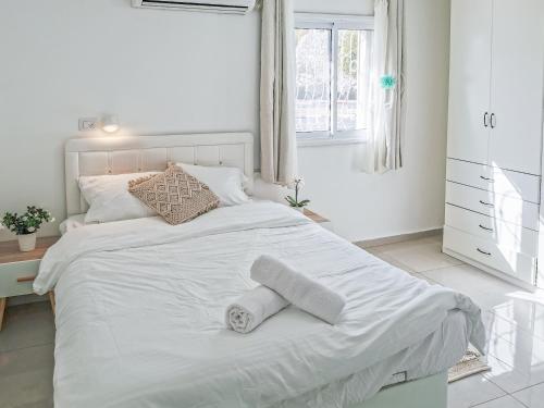 a bedroom with a white bed with two towels on it at Fully Equipped In A Central Location in Eilat