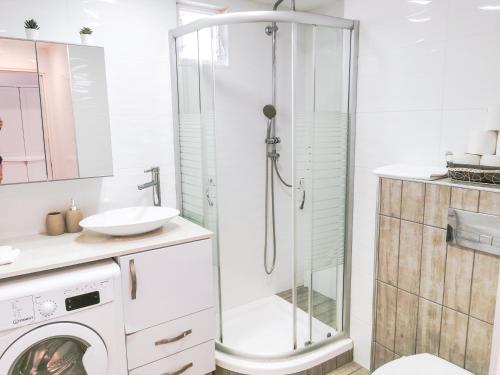 a bathroom with a shower and a washing machine at Fully Equipped In A Central Location in Eilat