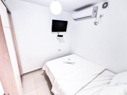 a small white room with a bed and a tv at Great Location Fully Equipped in Eilat