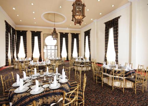 a banquet hall with tables and chairs and a clock at Hotel & Spa Hacienda Baruk in Zacatecas