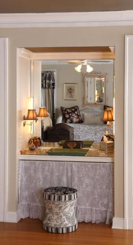 a living room with a bed and a mirror at Lilac Inn in Brandon