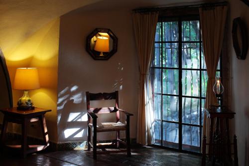 a chair and a lamp in a room with a window at Hacienda San Gabriel de las Palmas in Amacuzac