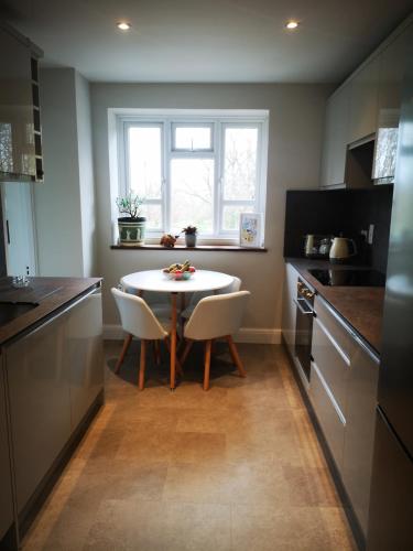 a small kitchen with a table and chairs in it at Muswell Hill Apartment FREE PARKING in London