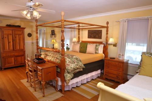 a bedroom with a four poster bed and a desk at Lilac Inn in Brandon