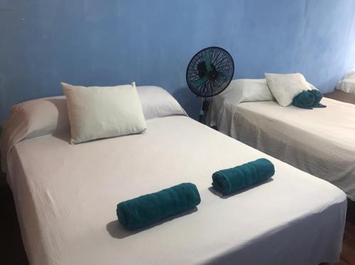 2 cuscini verdi posti su un letto in una stanza di Hotel Green Mountain Cahuita a Cahuita