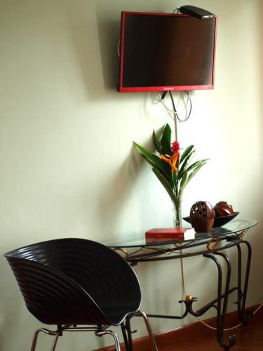 a black chair sitting next to a table with a tv at Caribbean Villages Aparments in Bocas del Toro
