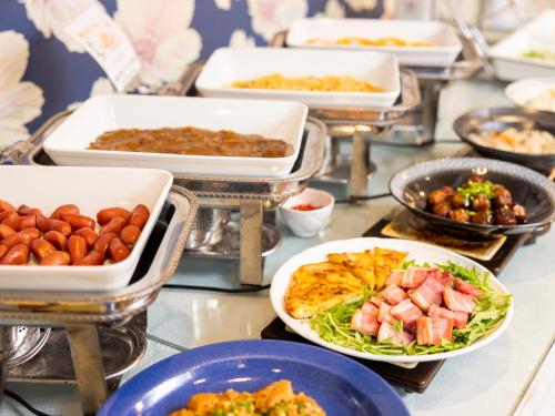 a buffet filled with different types of food in trays at Hotel Dorf Shizuoka in Shizuoka