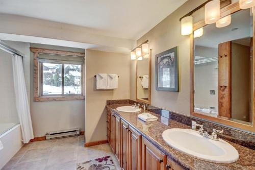 La salle de bains est pourvue de 2 lavabos et d'un grand miroir. dans l'établissement Ten Mile Condo - Best in Breck, à Breckenridge