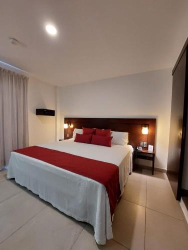 a hotel room with a large bed with red pillows at Hotel Real Alma in Oaxaca City