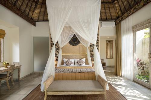 1 dormitorio con 1 cama con mosquitera en The Sun of Granary Resort and Villas, en Ubud