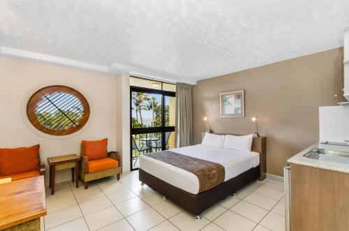 a hotel room with a bed and a kitchen at Waters Edge The Strand in Townsville