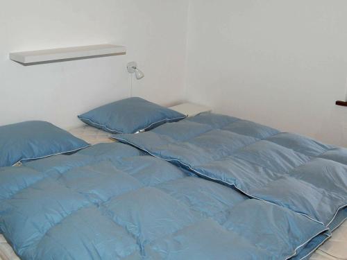 ホにあるTwo-Bedroom Holiday home in Blåvand 9のベッド1台(青いシーツ付)