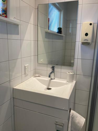 Baño blanco con lavabo y espejo en Gisborne Dream Suite en Gisborne