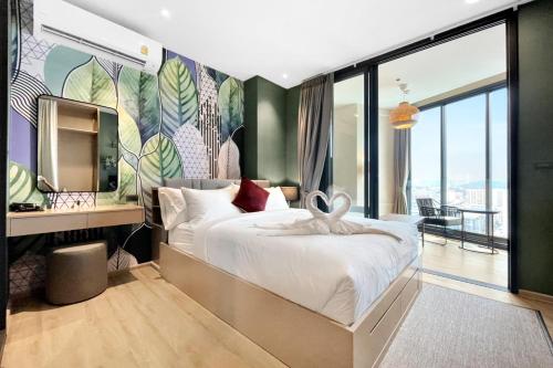 a bedroom with a large bed with a mural at Edge Central Pattaya by J&P in Pattaya