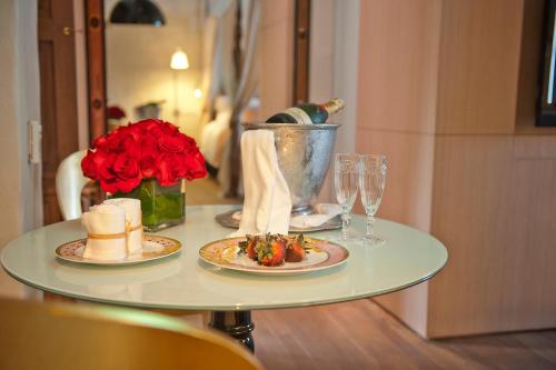 a table with two plates of food and wine glasses at Sofitel Legend Santa Clara Cartagena in Cartagena de Indias