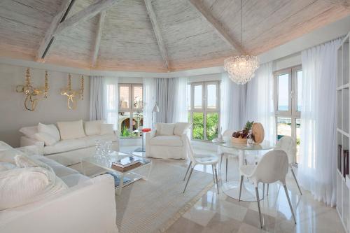 a living room with white furniture and a chandelier at Sofitel Legend Santa Clara Cartagena in Cartagena de Indias