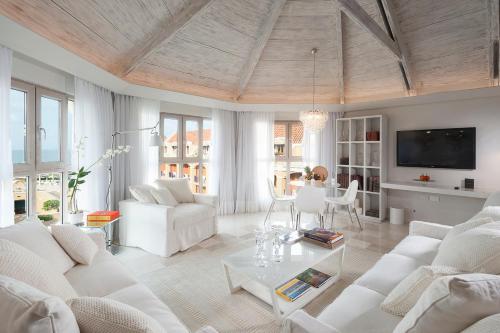 a living room with white couches and a tv at Sofitel Legend Santa Clara Cartagena in Cartagena de Indias