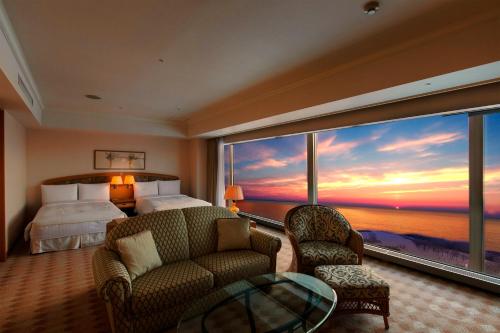Habitación de hotel con cama y ventana grande en The Windsor Hotel Toya Resort & Spa, en Lago Toya