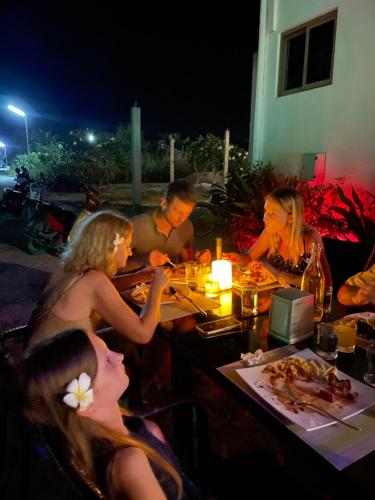 un gruppo di persone sedute a tavola che mangiano cibo di Olive Goidhoo a Fehendhoo