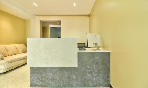 a reception desk in a room with a couch at Treebo Sriz Cozy Seethamadhara in Visakhapatnam