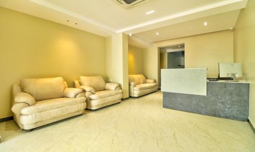 a lobby with two chairs and a desk with a screen at Treebo Sriz Cozy Seethamadhara in Visakhapatnam