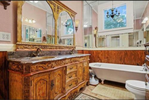 a bathroom with a wooden vanity and a tub and a sink at McKean Manor in Mobile
