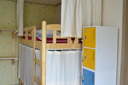 a bunk bed in a room next to a refrigerator at Gyeongju Momojane Guesthouse in Gyeongju