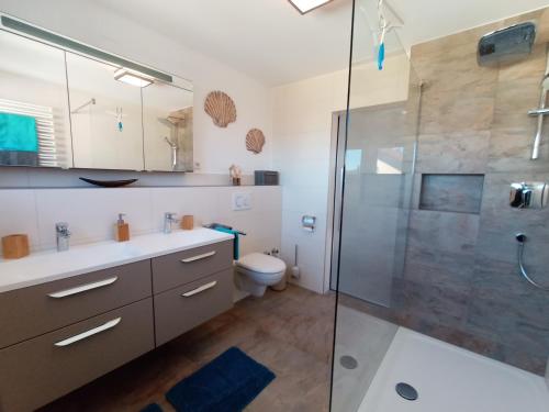 a bathroom with a shower and a sink and a toilet at BodenSEE Apartment Langenargen Möwenweg in Langenargen