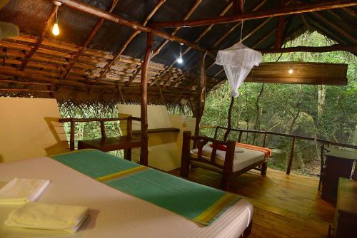 ein Schlafzimmer mit einem Bett und einem Stuhl in einem Zimmer in der Unterkunft Back of Beyond - Pidurangala in Sigiriya
