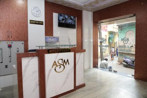 a man sitting in front of a counter in a building at Hotel Al Sharif Manzil 90 Mtrs from Dargah in Ajmer