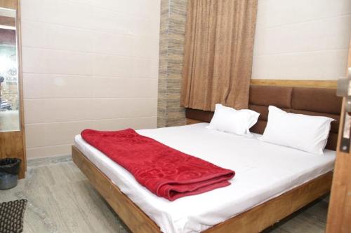 a bedroom with a bed with a red blanket on it at Hotel Al Sharif Manzil 90 Mtrs from Dargah in Ajmer