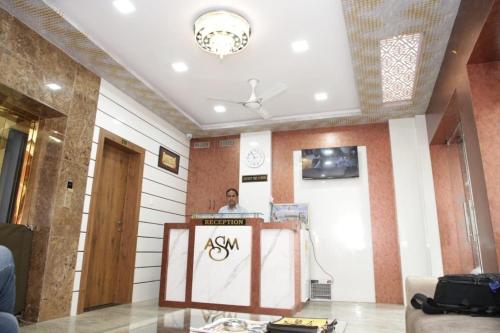 a man standing behind a podium in a room at Hotel Al Sharif Manzil 90 Mtrs from Dargah in Ajmer
