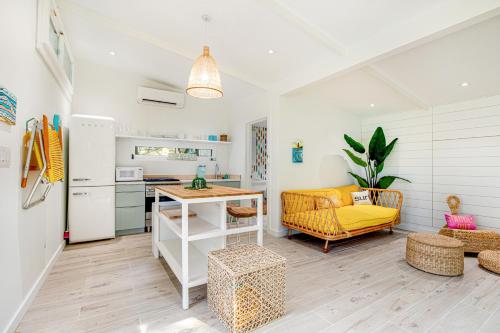 a kitchen and a living room with a table at The Other Place Cottage C in Folly Beach