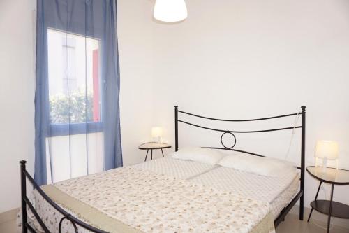 una camera bianca con un letto nero e una finestra di Relax by the garden - flat for up to 6 guests a Porto Santa Margherita di Caorle