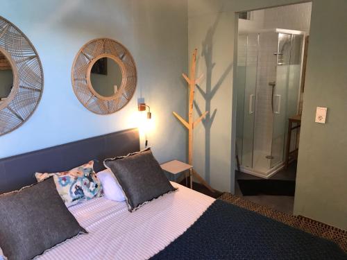 ein Schlafzimmer mit einem Bett und zwei Spiegeln an der Wand in der Unterkunft Chambre Vinc in Bastia