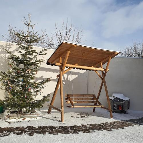 a wooden picnic shelter next to a christmas tree at Lina Agropanzió in Tomeşti