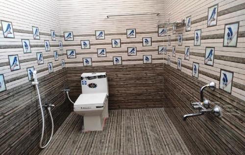 bagno con servizi igienici e quadri alle pareti di Le Springlynn Residency a Pondicherry